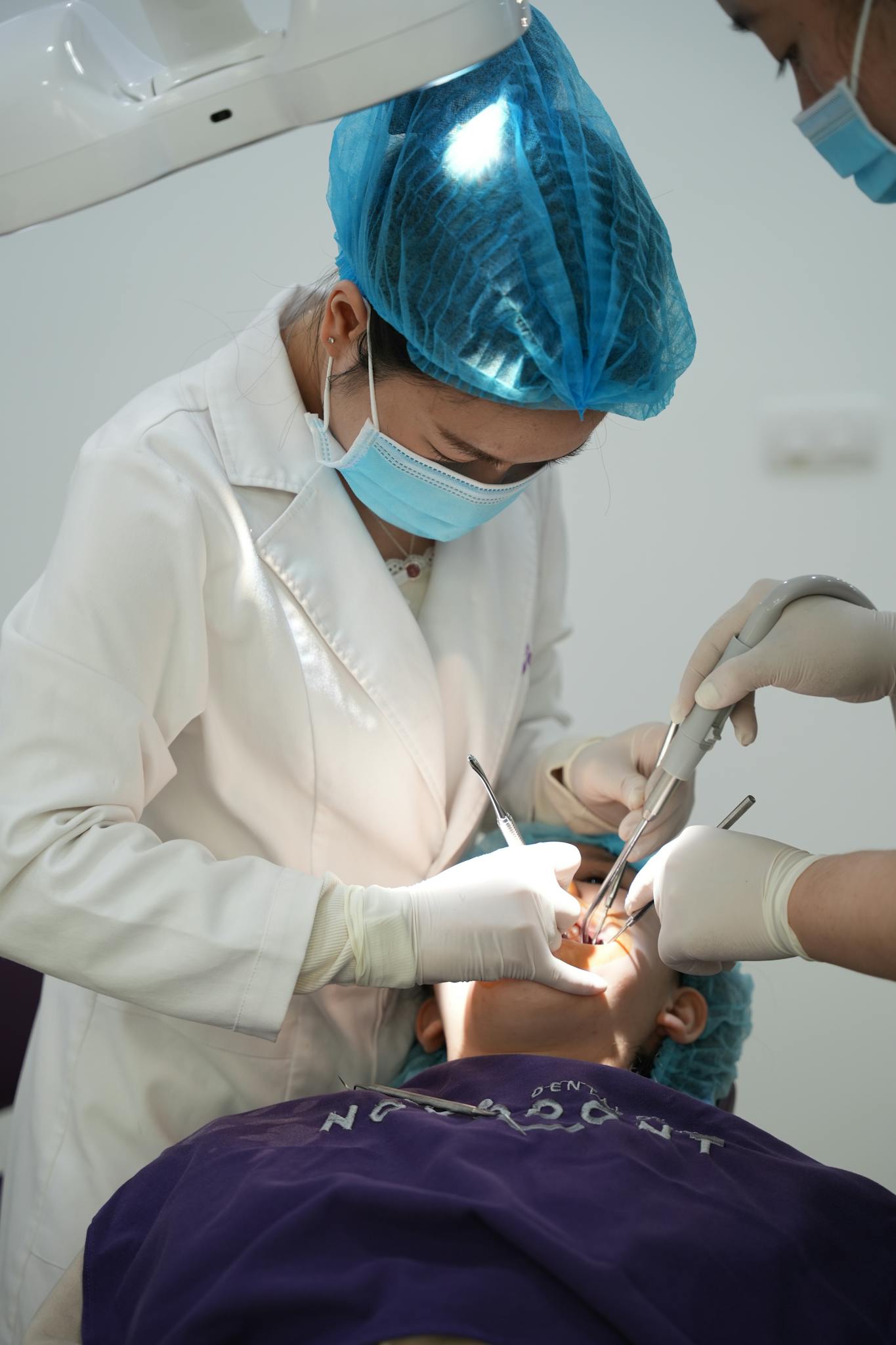 Dentist conducting an oral examination in a dental clinic with surgical instruments.